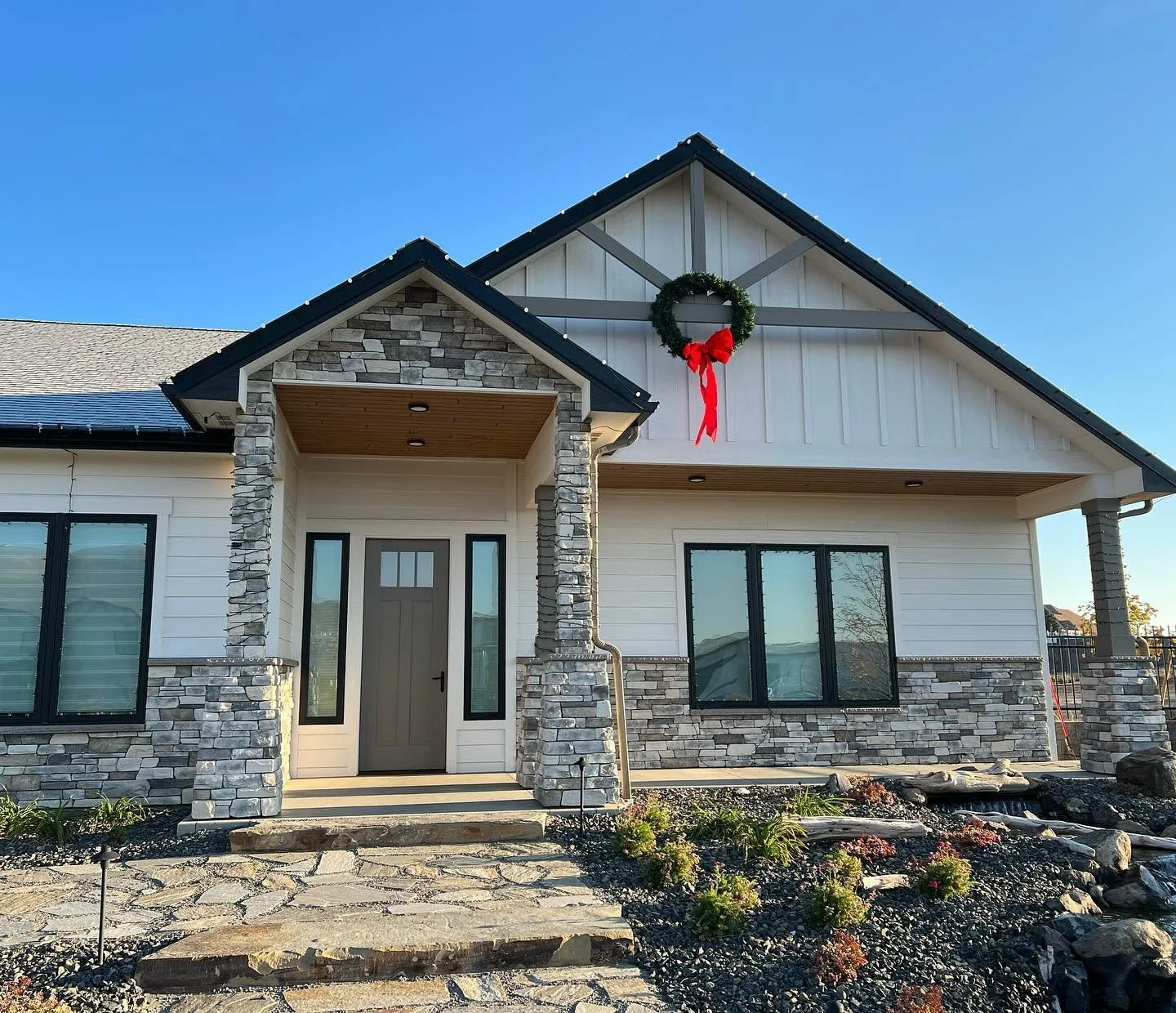 White home with stone-clad entrance columns and gable by Alano Masonry